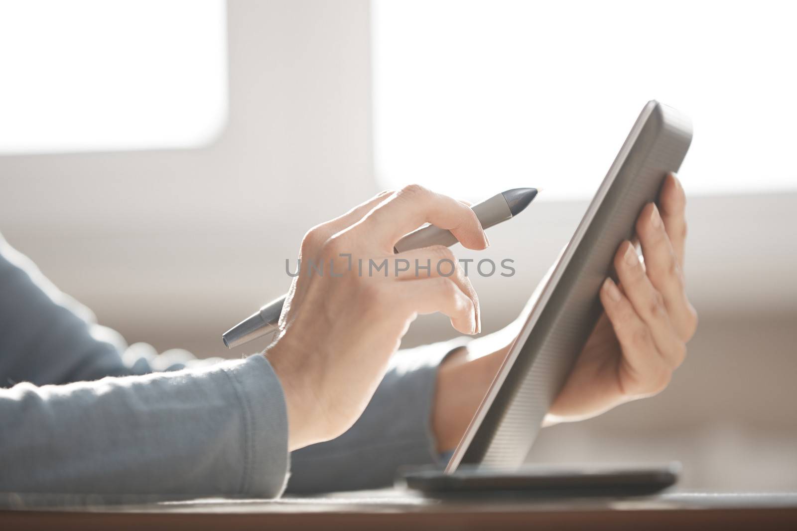 Hands of designer working with tablet PC and stylus