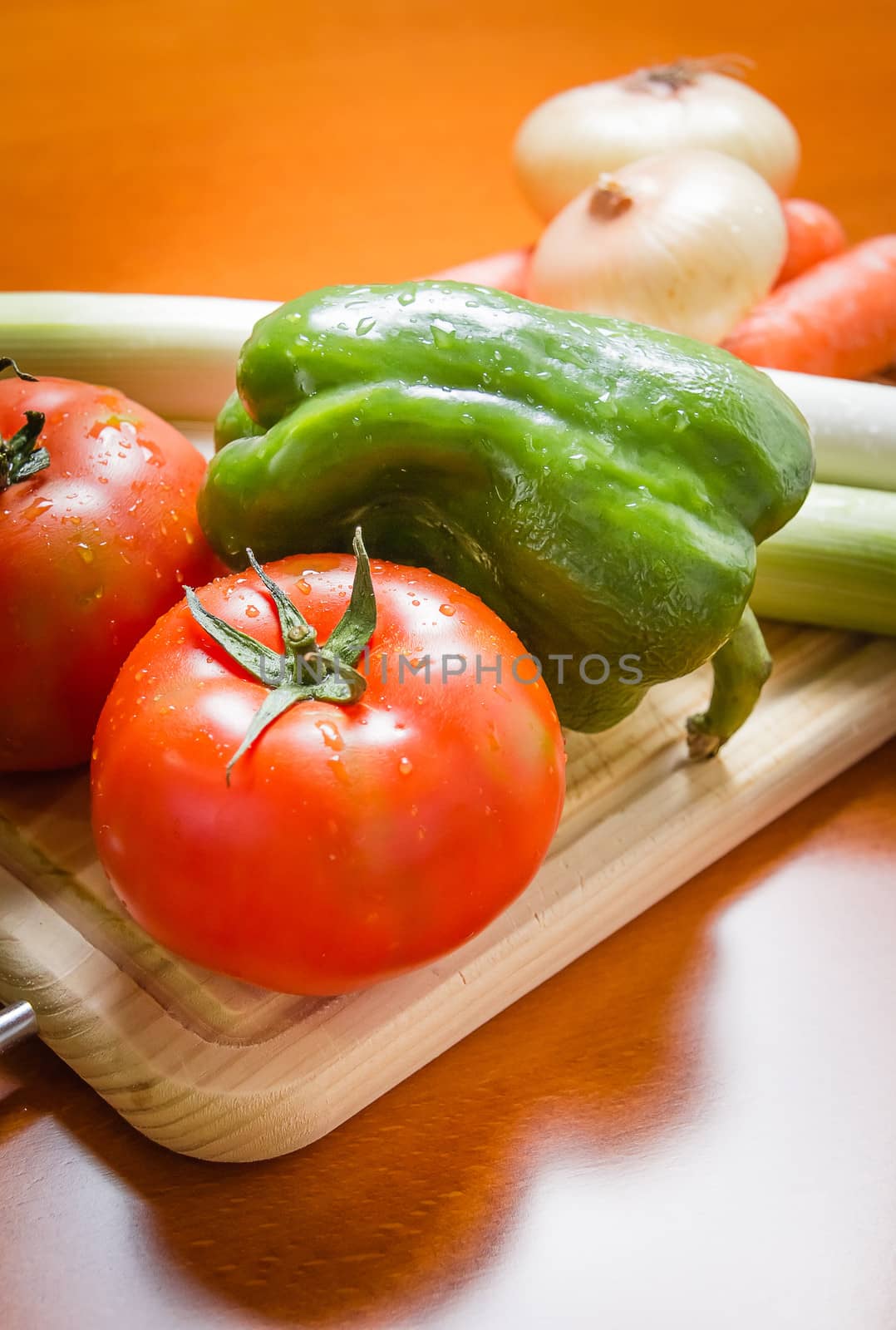 Fresh vegetables on cutting board in a wooden kitchen table