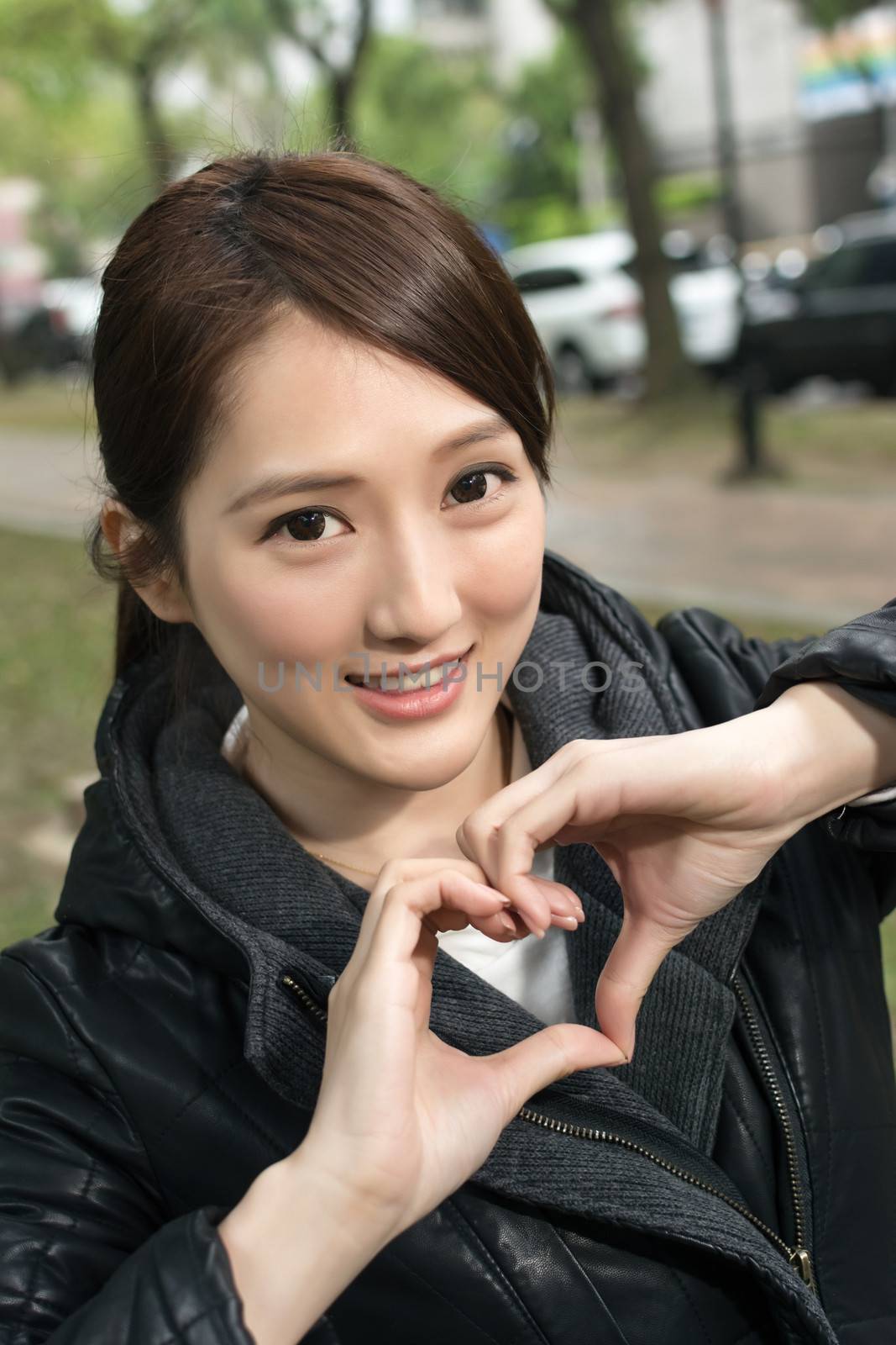 Asian young woman give you a gesture heart shape, close up portrait.