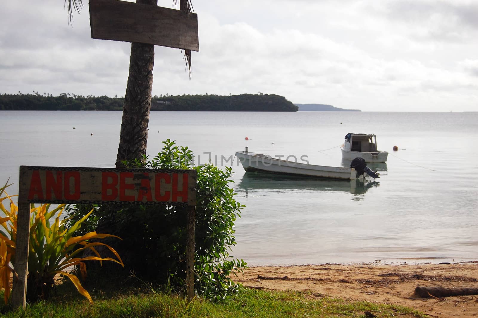 Boat near beach with timber name plate, Kingdon of Tonga
