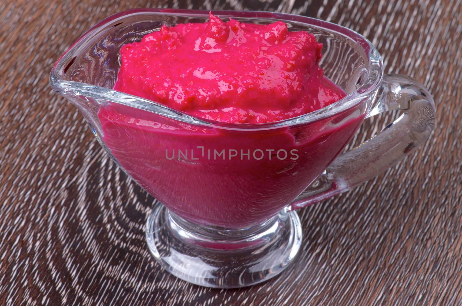 Delicious Beet Horseradish in Glass Gravy Boat isolated on Wooden background