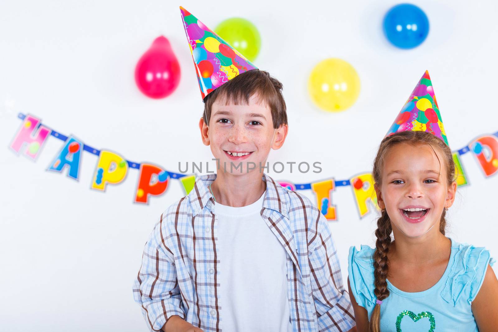 Cute girl and boy having fun at birthday party