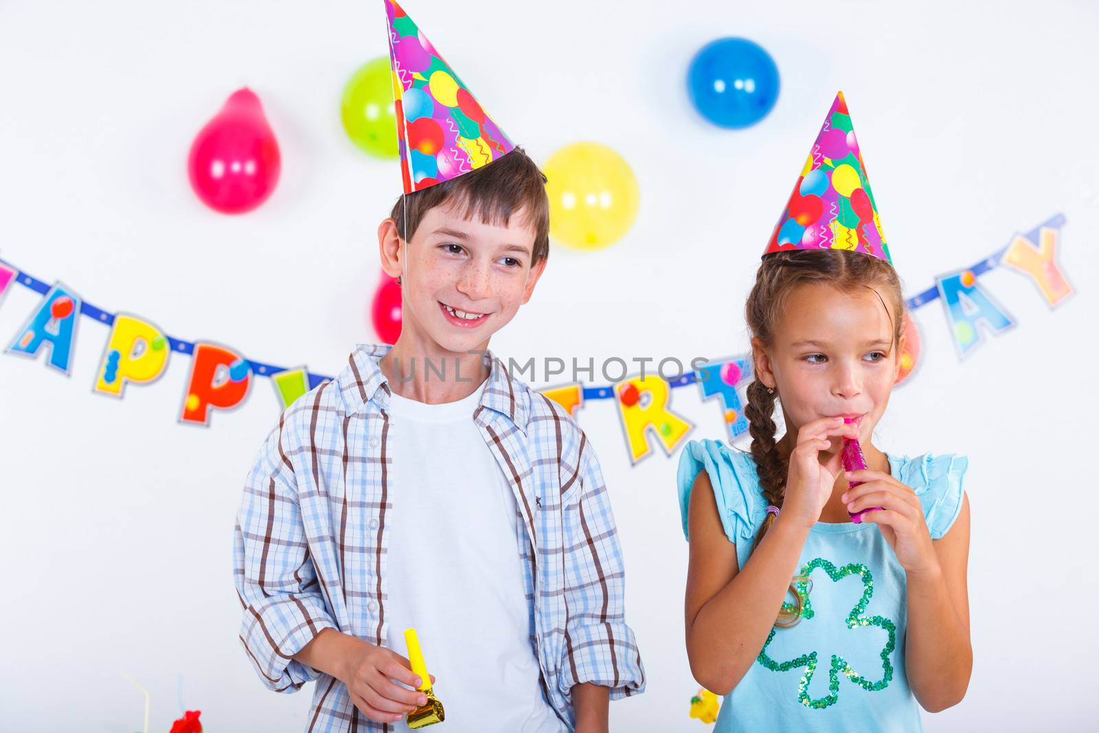 Cute girl and boy having fun at birthday party