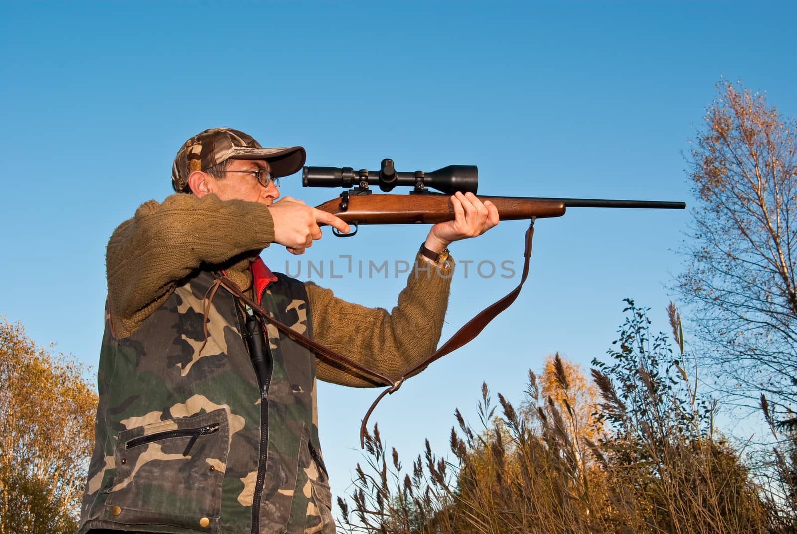 Hunter aiming mooses with telescopic sights on rifl