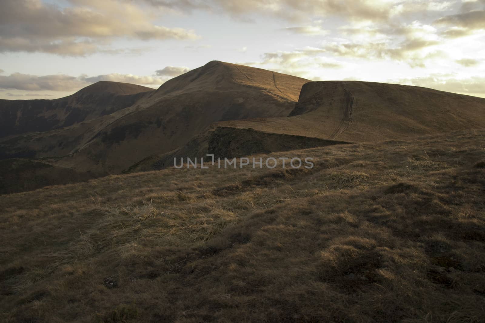 Mountain peaks in the autumn evening sky with clouds