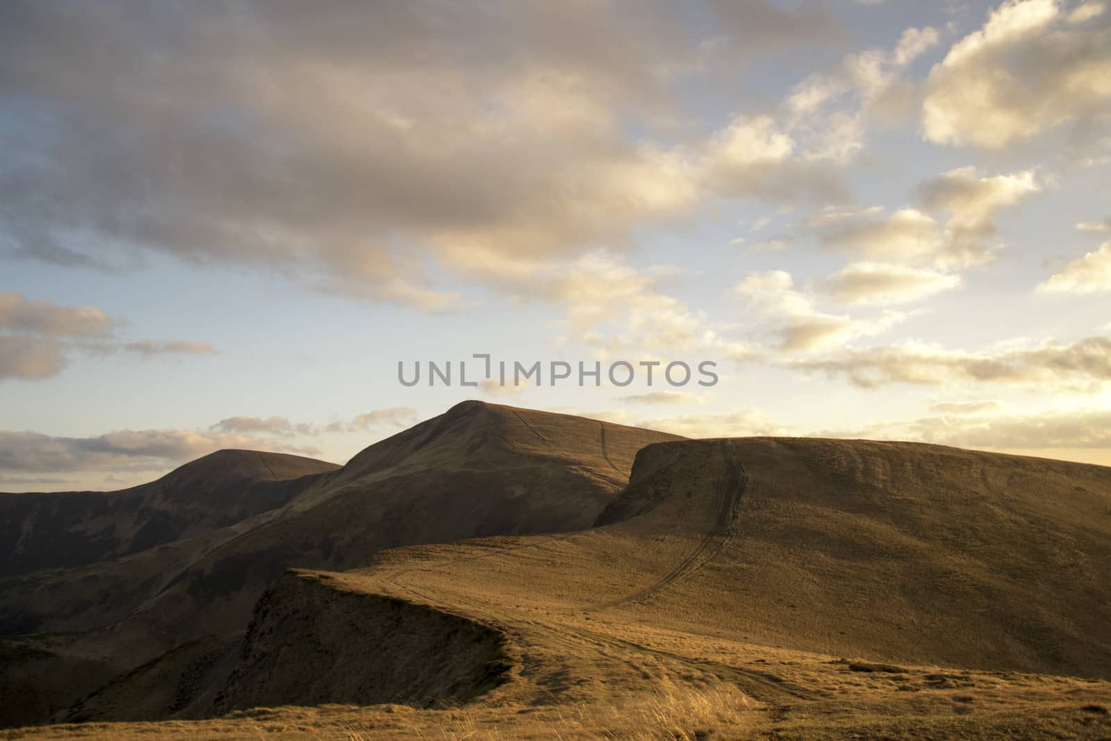 Mountain peaks in the autumn evening sky with clouds