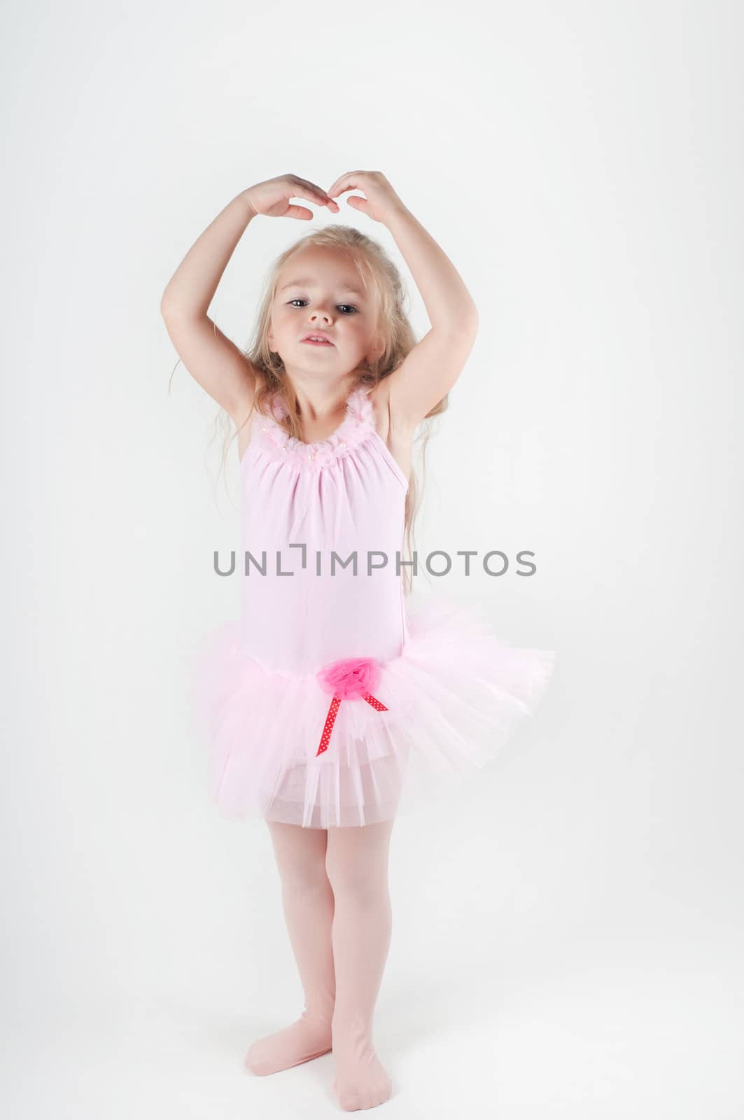 Studio shot of little ballet dancer girl doing pas