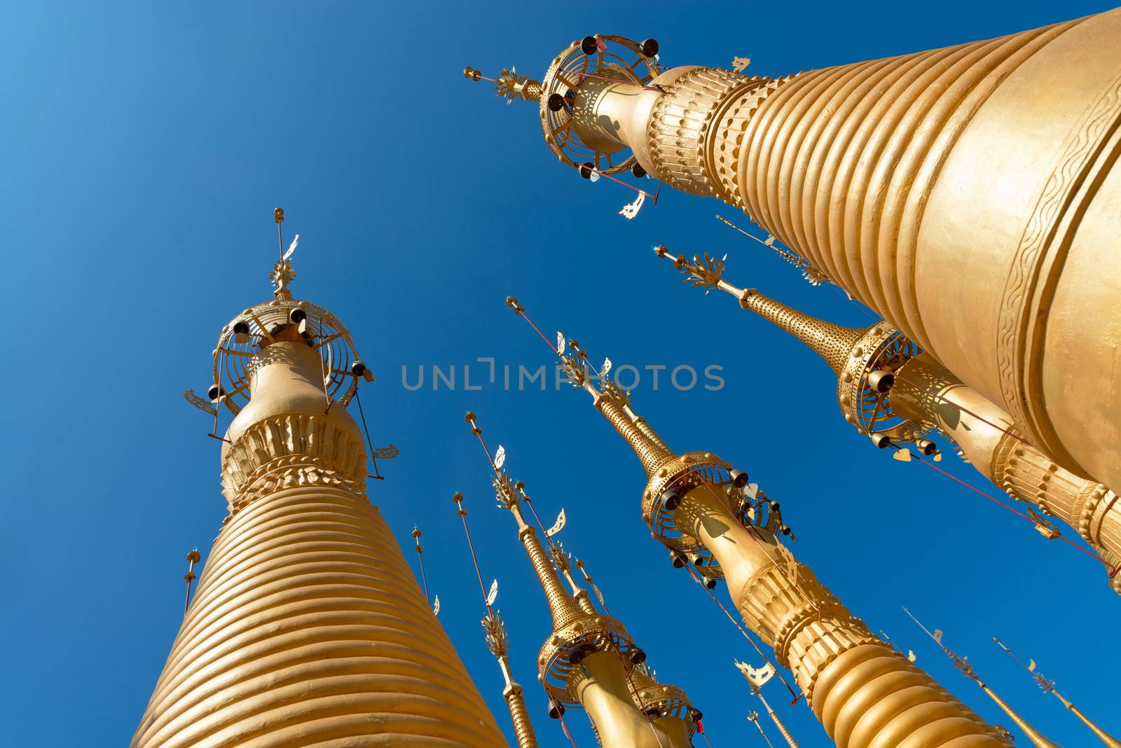 Tops of golden Shwe Inn Tain ancient Burmese Buddhist pagoda in the village of Indein on Inlay Lake in Shan State, Myanmar (Burma).