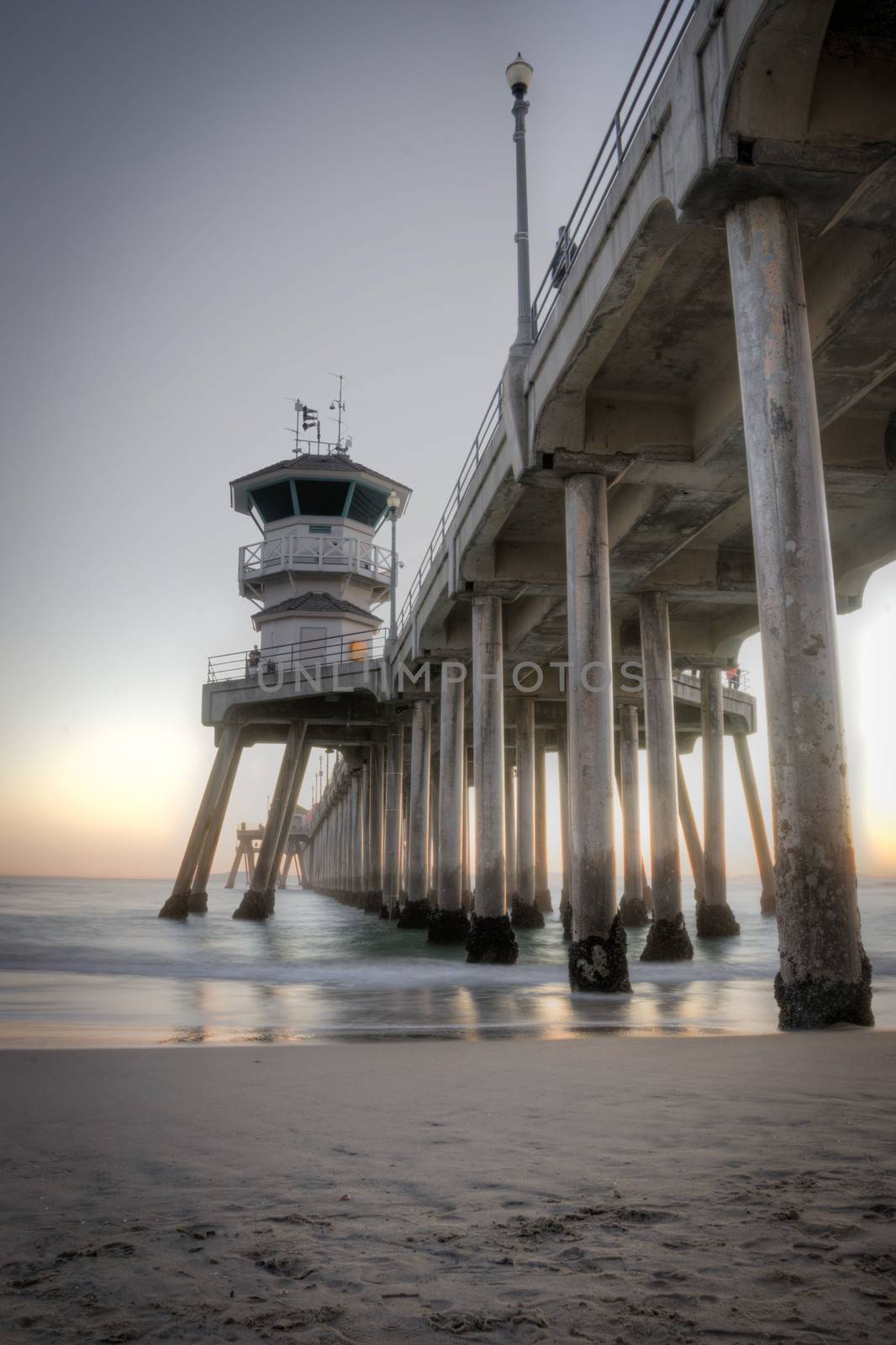 Long exposure captures slow moving waves under The Huntington Beah Pier in Huntington Beach, California