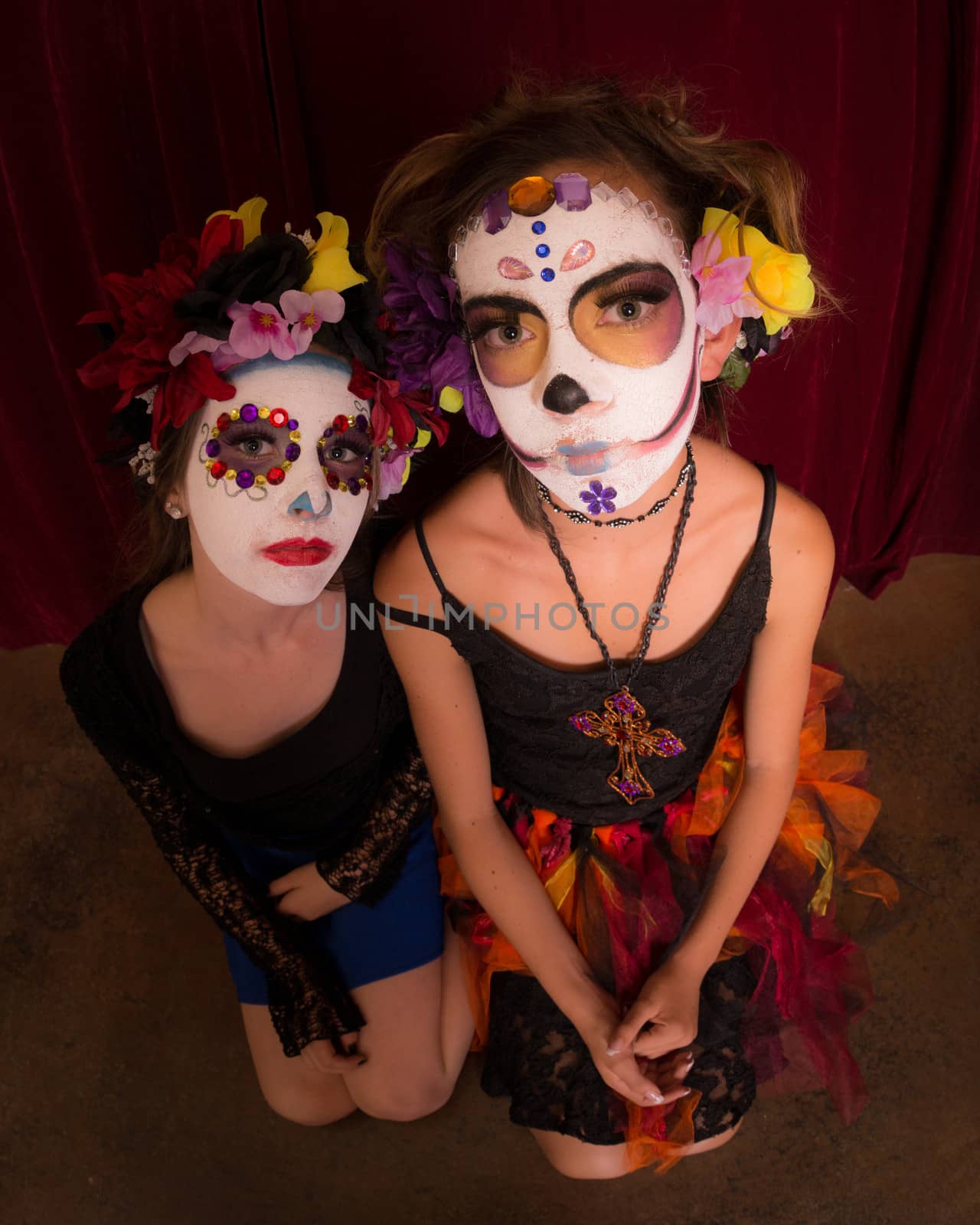 Teens dressed in Day of The Dead costumes and colorful make up pose. Wide angle lens accentuates face