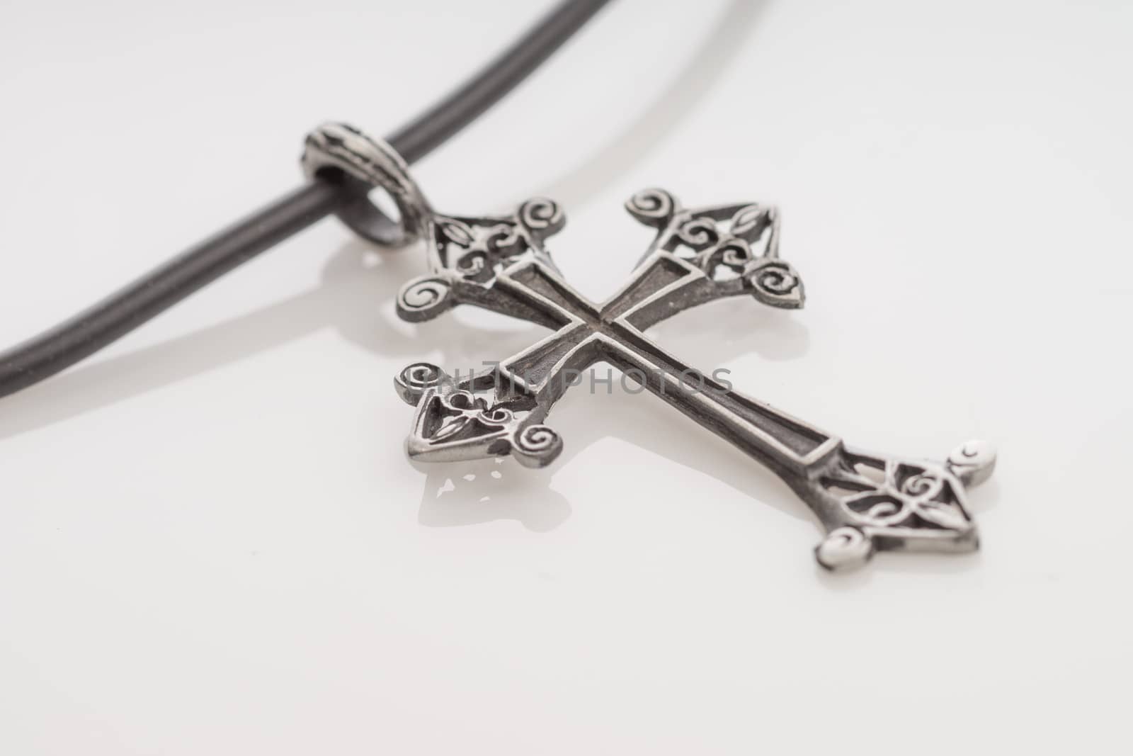 Decorative cross on white background with slight reflection