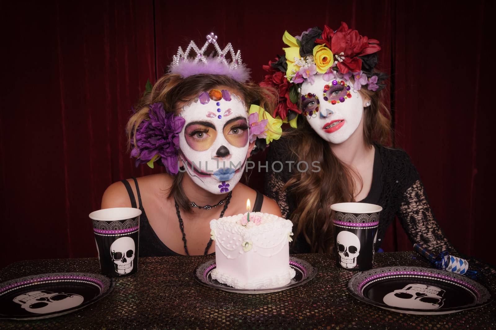 Day of The Dead girls in costume and make up celebrating birthday with cake