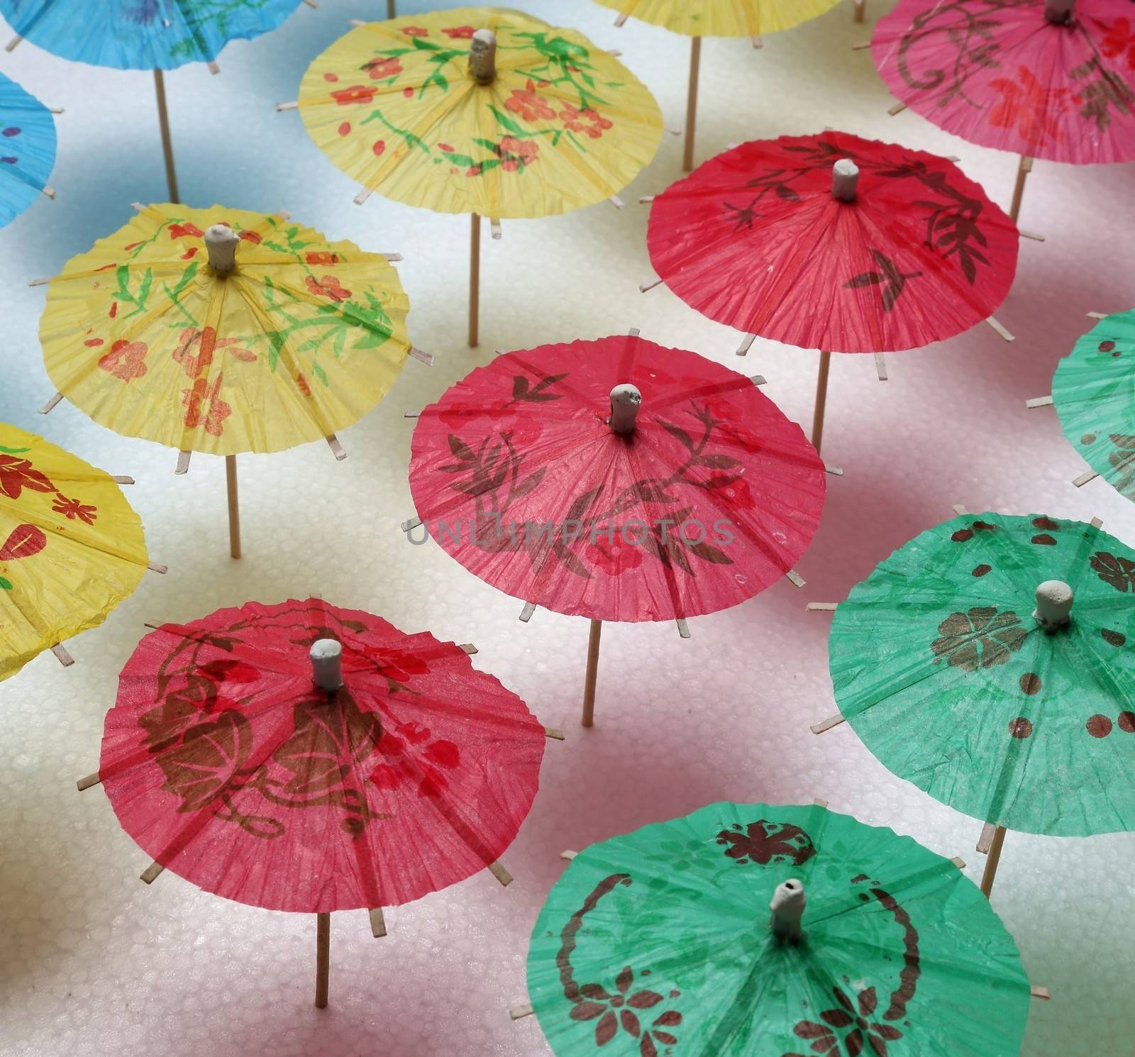 Cocktail umbrellas of different colors arranged in a pattern