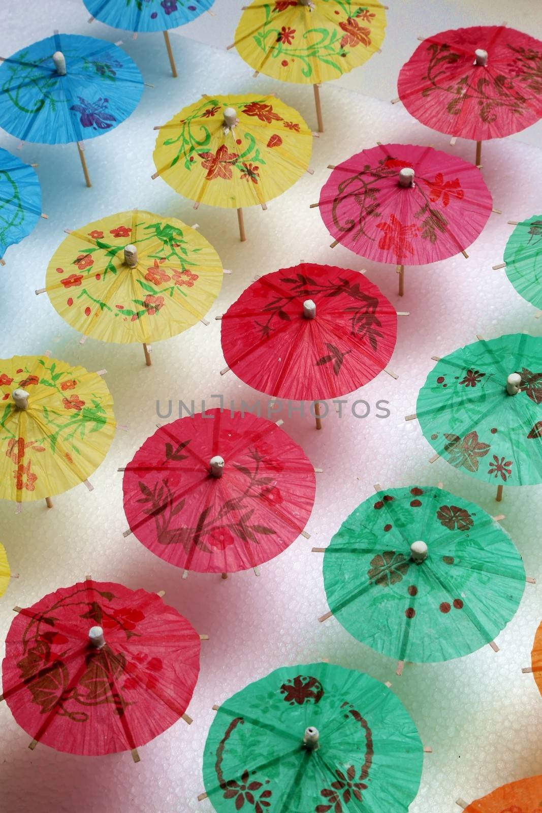 Cocktail umbrellas of different colors arranged in a pattern