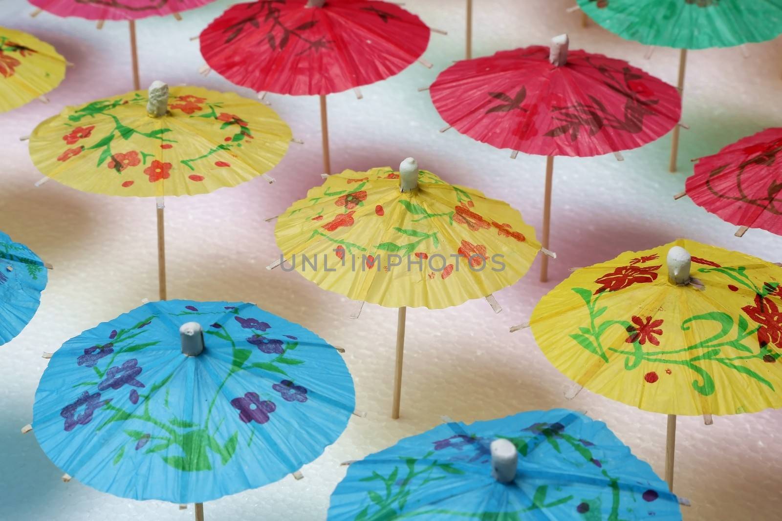 Cocktail umbrellas of different colors arranged in a pattern