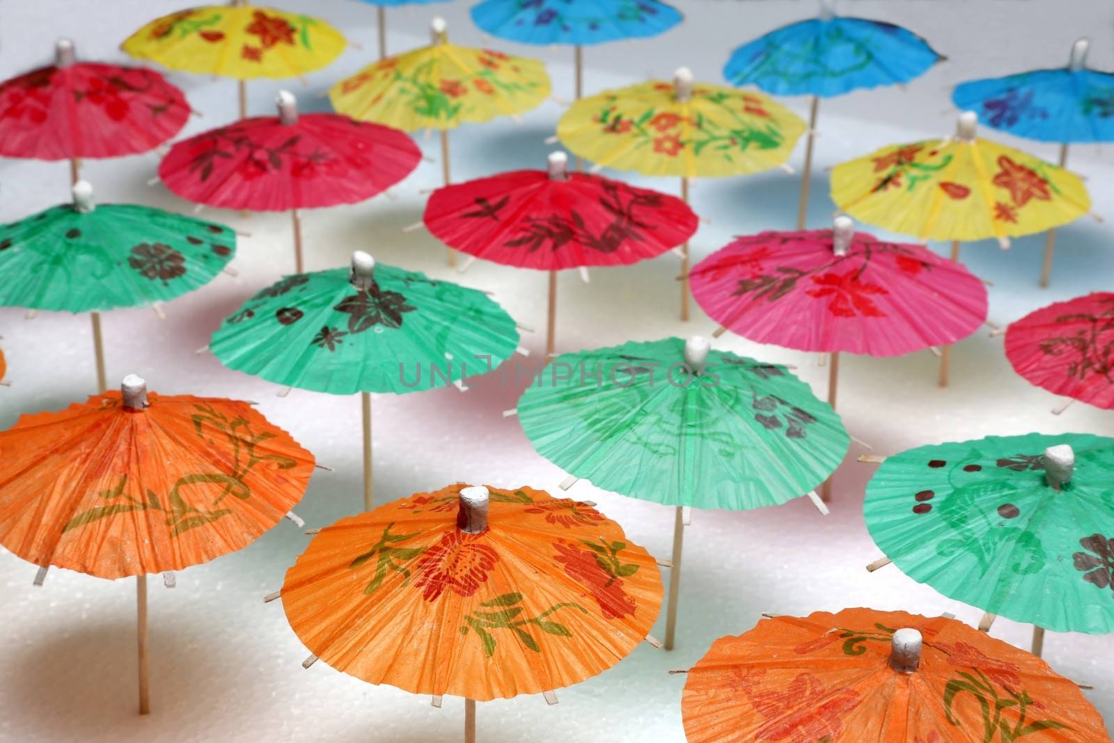 Cocktail umbrellas of different colors arranged in a pattern