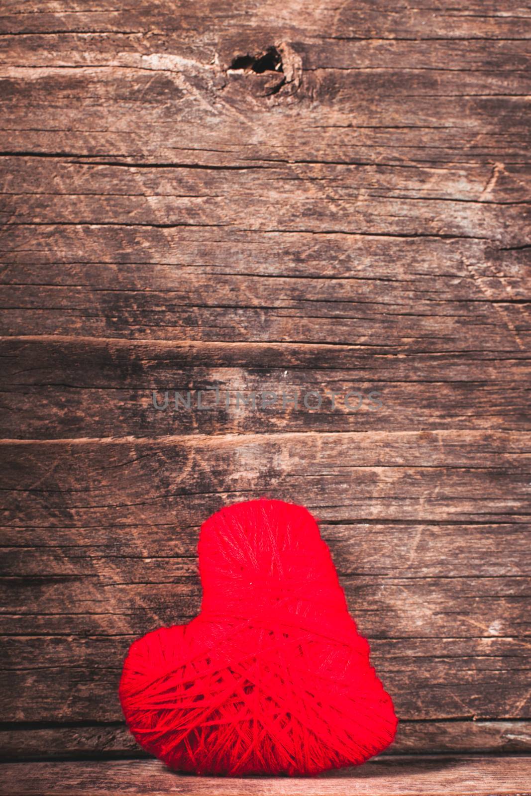 Red thread heart over old shabby background. Valentine concept