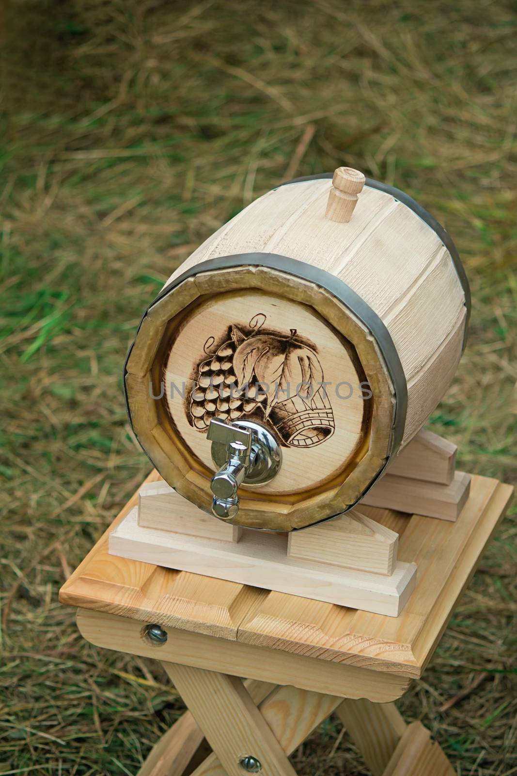 Beautifully decorated with oak barrel with a metal crane, is located on a convenient wooden stand.