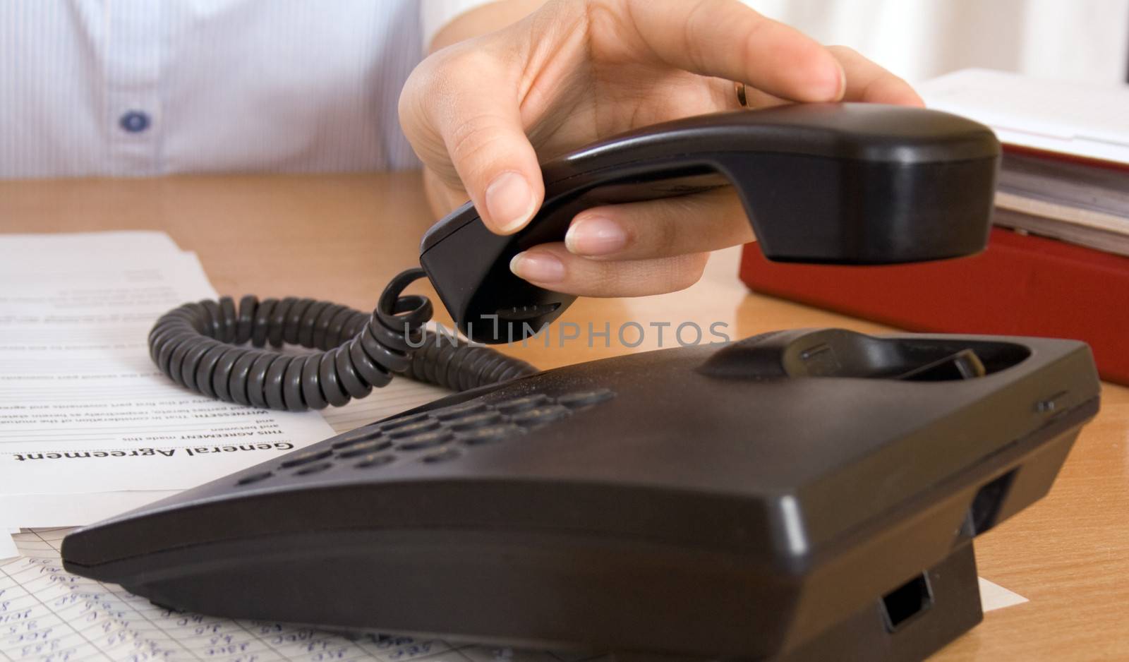 White woman's hand is reaching for a phone