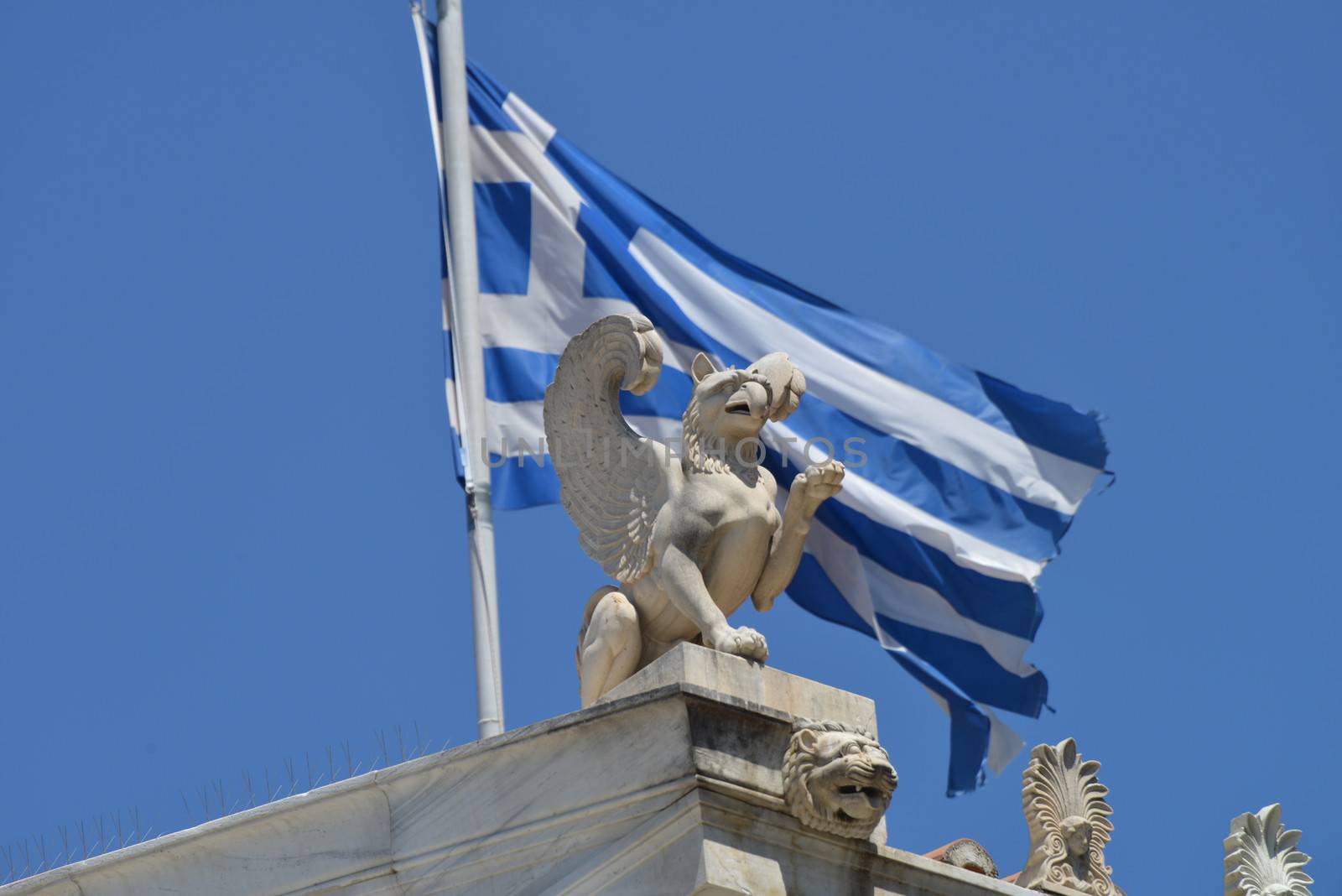 Flag of Greece behind a statue in Athens.