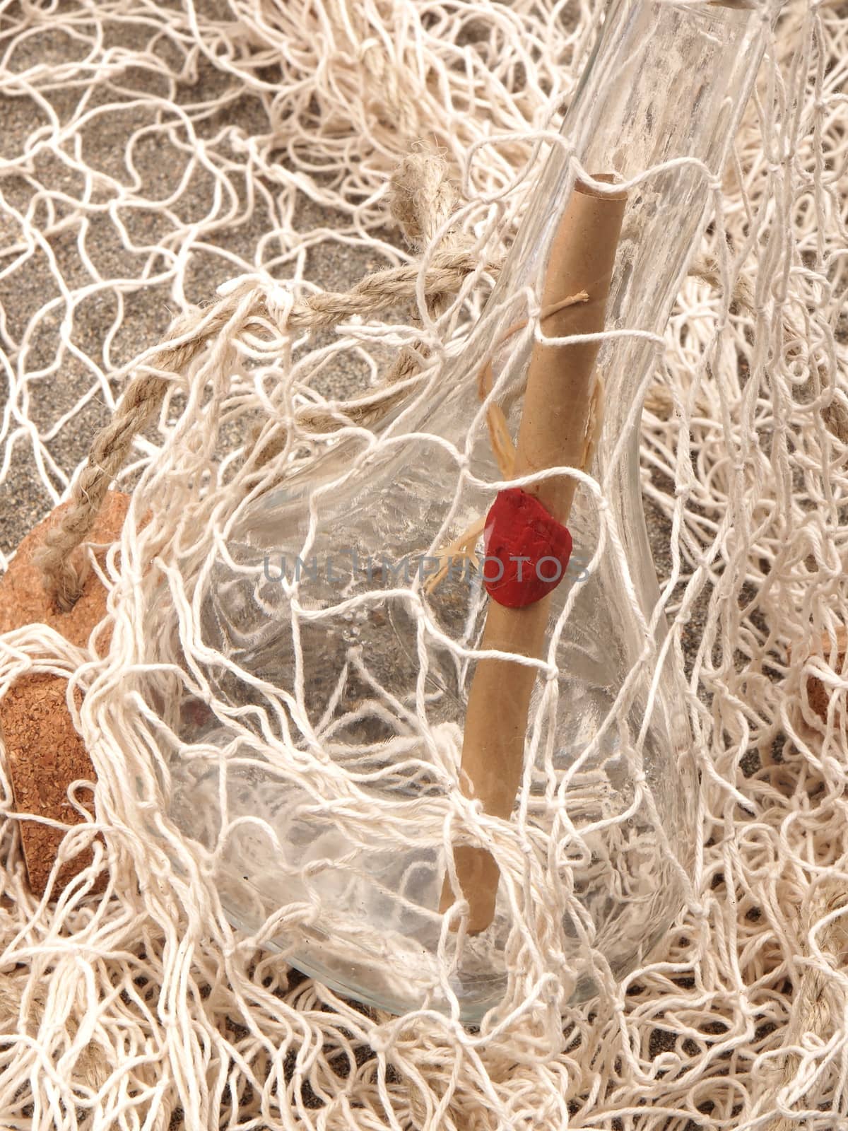 message in the bottle in the fishing net on the sand beach          