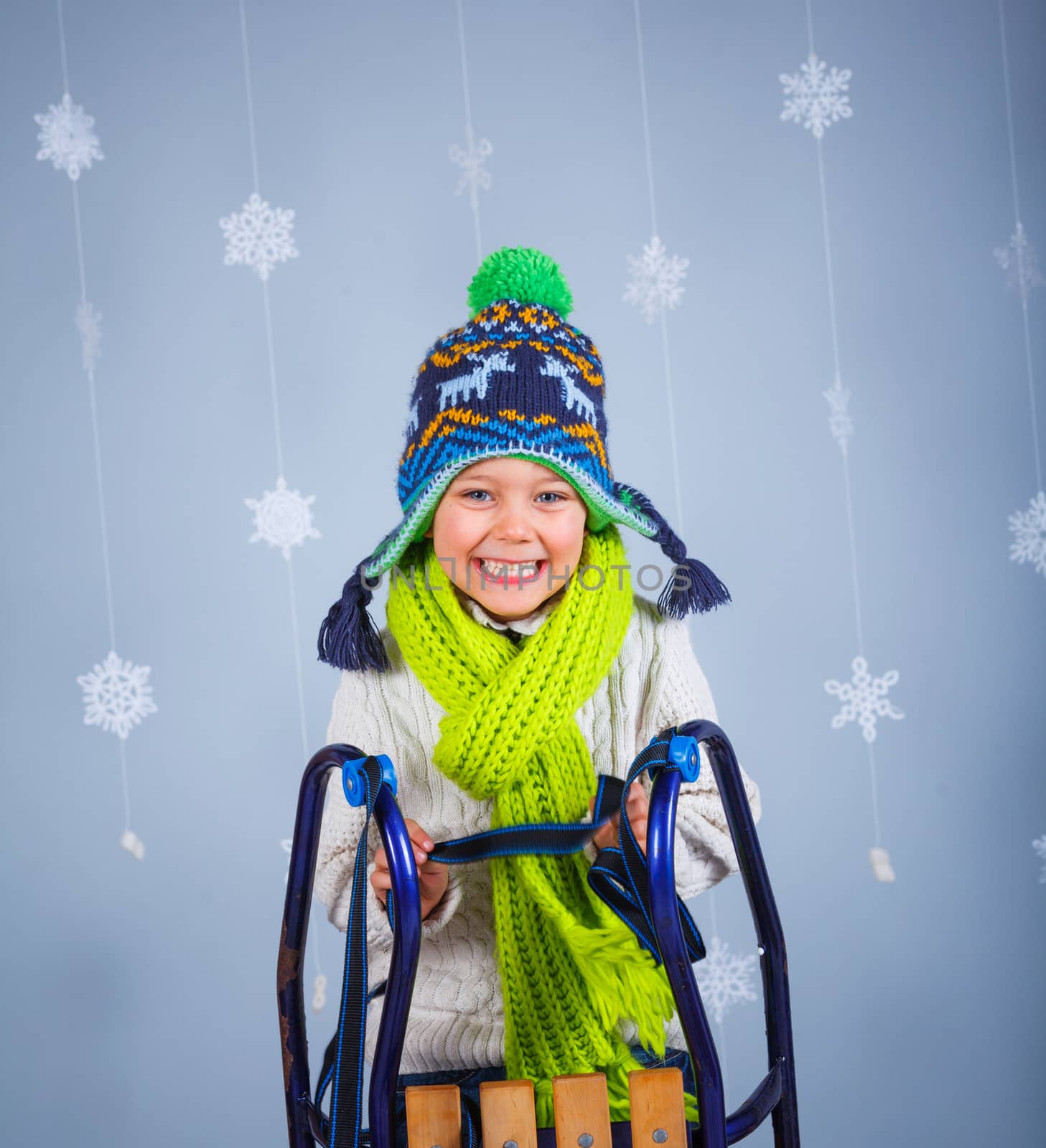 Winter Fashion. Portrait of adorable happy boy in winter hat gloves and sweater in studio.