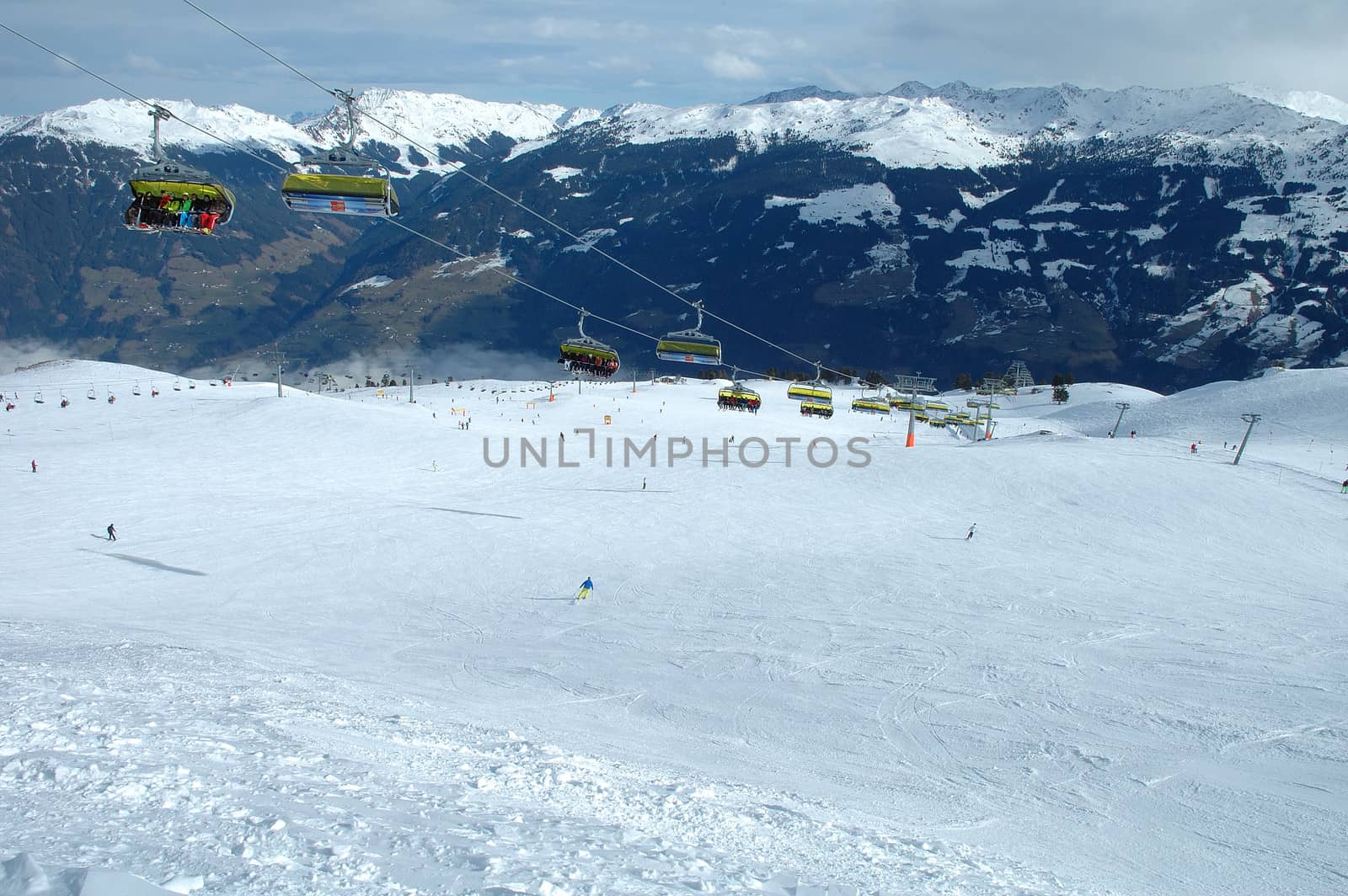 Ski lift, slope and skiers  nearby Kaltenbach in Zillertal valley in Austria