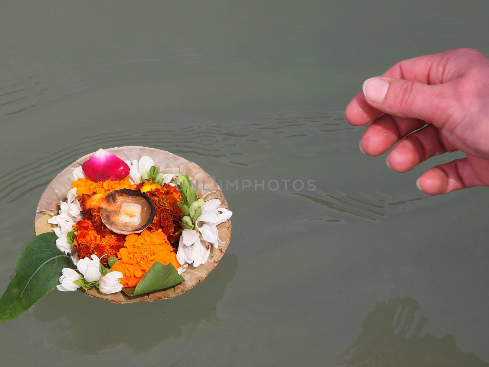 woman realising flover arangment on the ganges        