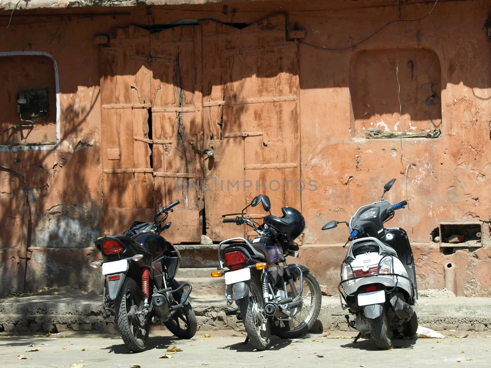 motorbikes parked infront of old red house in Jaipur,India     