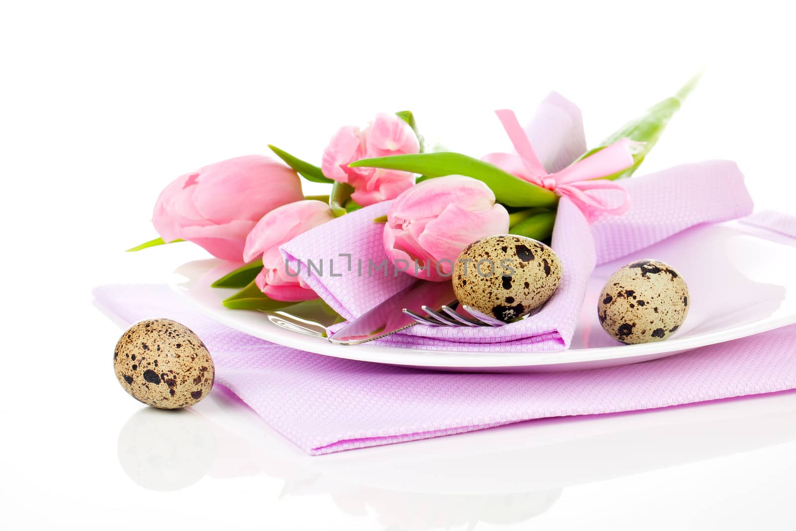pink tulips with quail eggs in a plate, on a white background.  romantic still life with fresh flowers