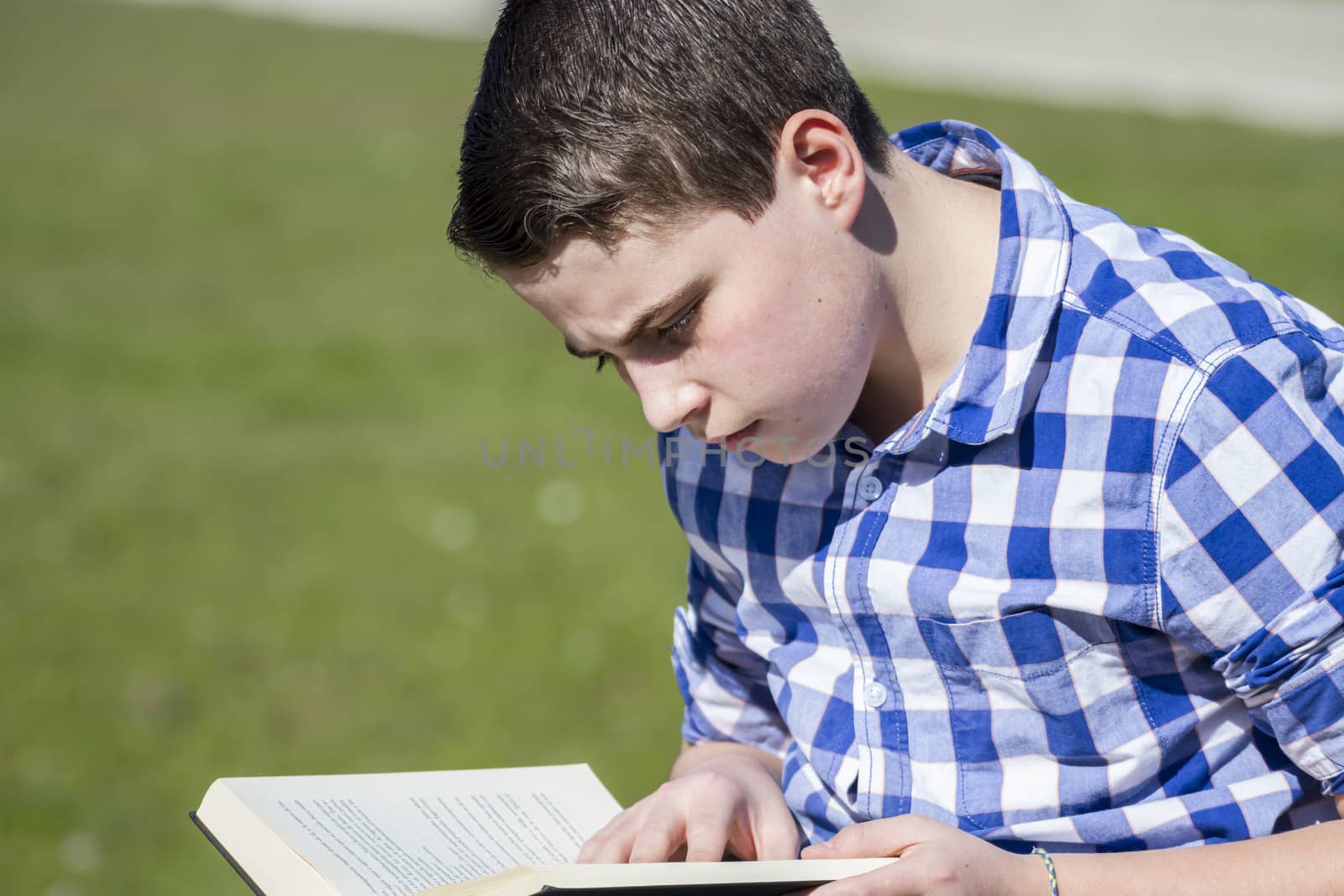 Teen.Young man reading a book in outdoor with yellow apple.