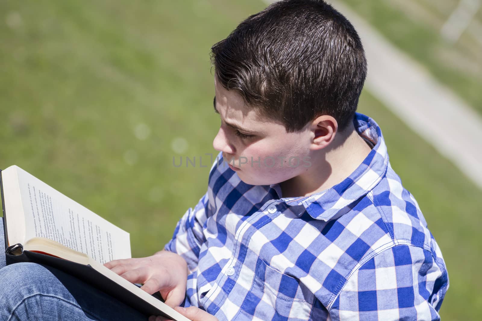 Teenager.Young man reading a book in outdoor with yellow apple.