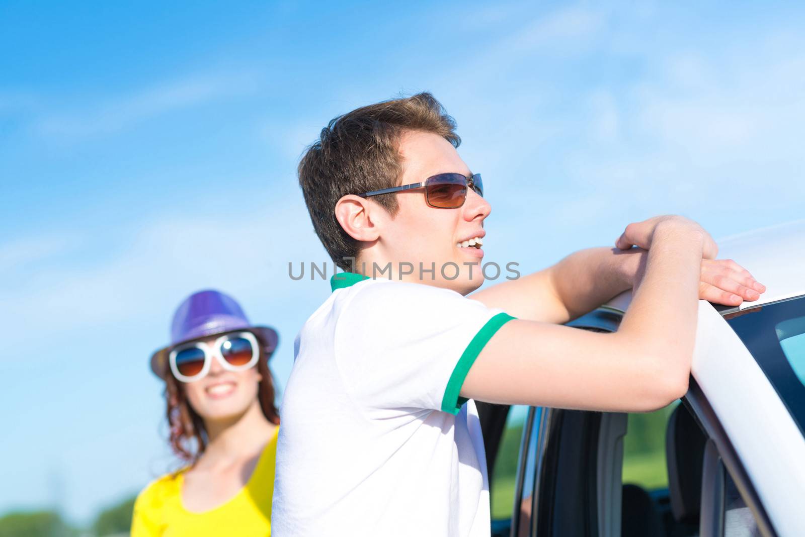 young man in sunglasses standing next to the car, the summer road trip