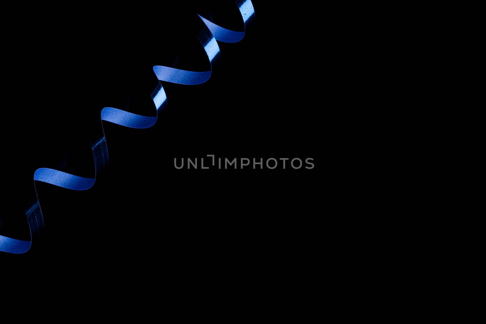 photo of a Blue streamer with reflection on black backround