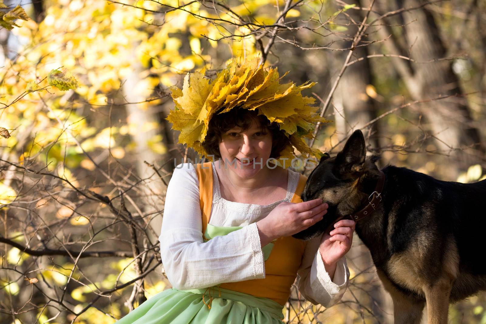 Woman and dog in autumn forest
