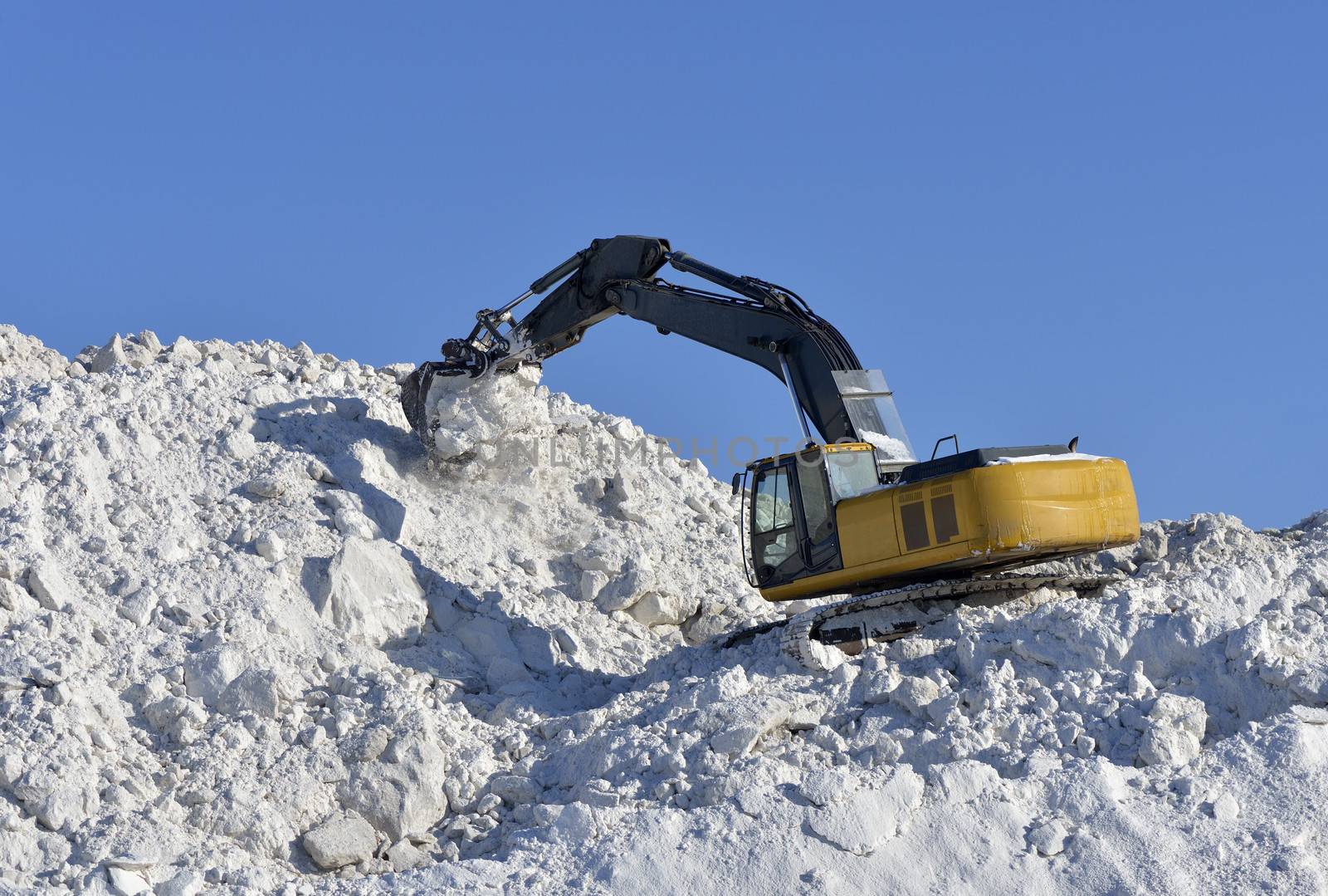 Excavator stacked to store snow in winter 