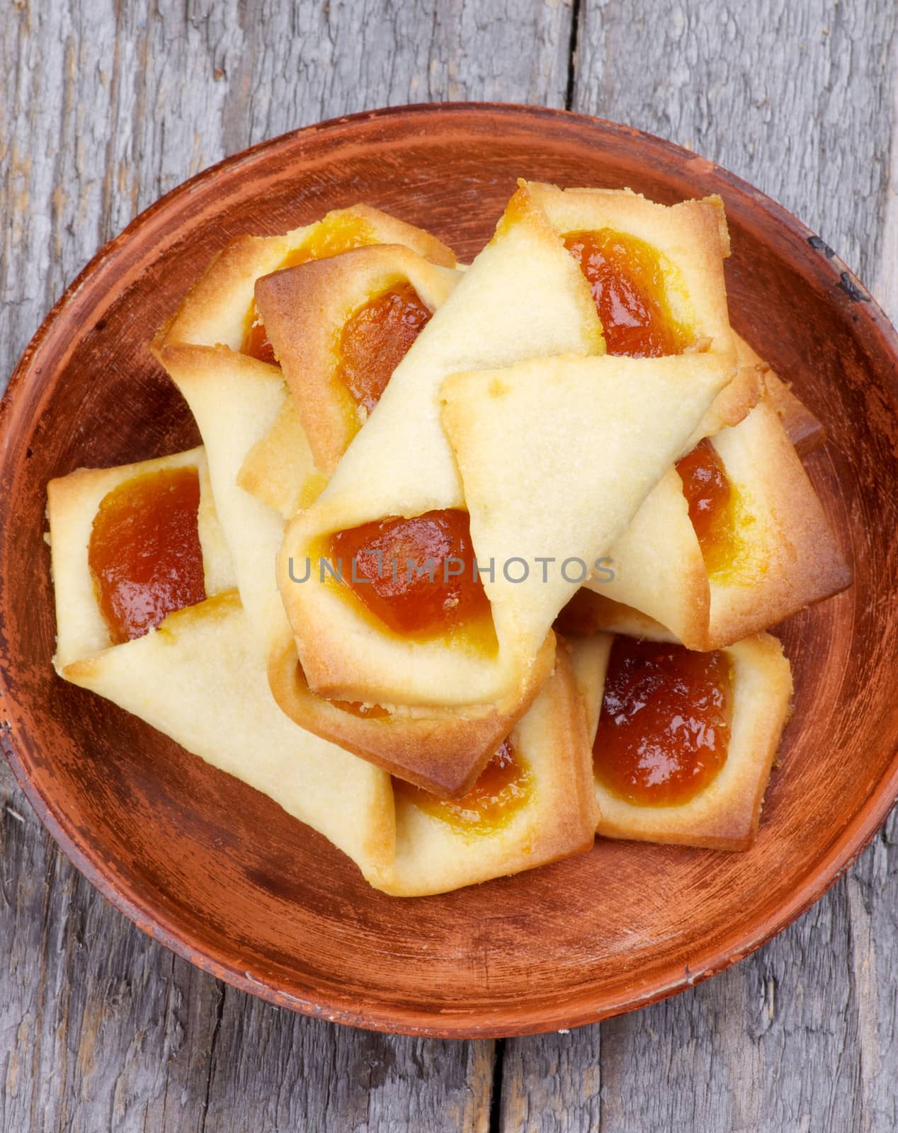 Homemade Cookies with Berries Jam Wrapped on Brown Plate isolated on Rustic Wooden background. Top View