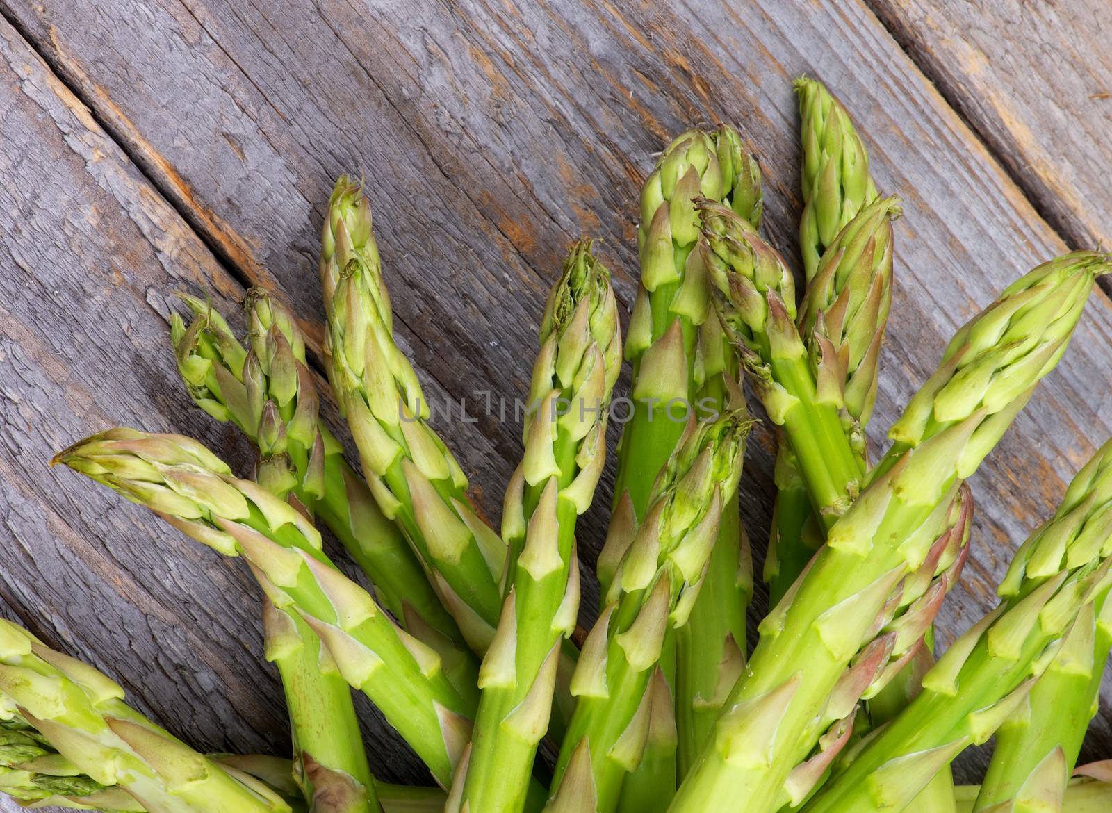 Heap of Asparagus Sprouts isolated on Rustic Wooden background. Top View