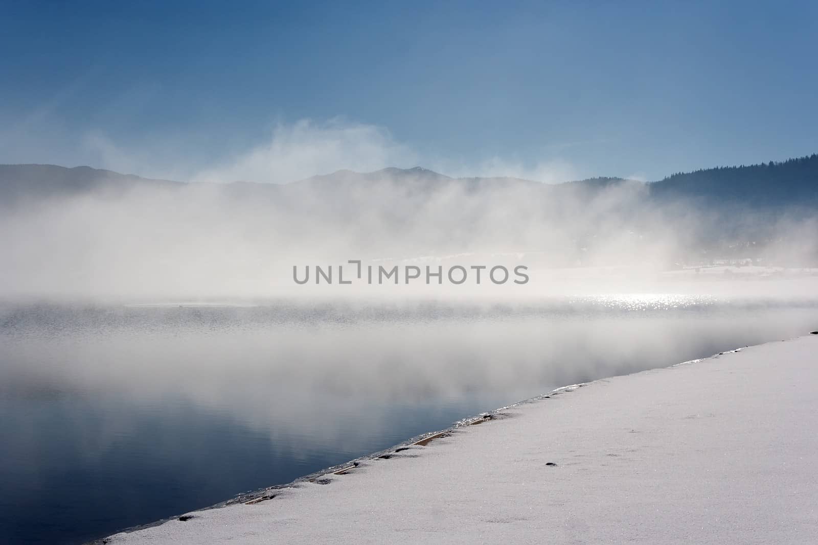 fog over lake in winter by mitakag