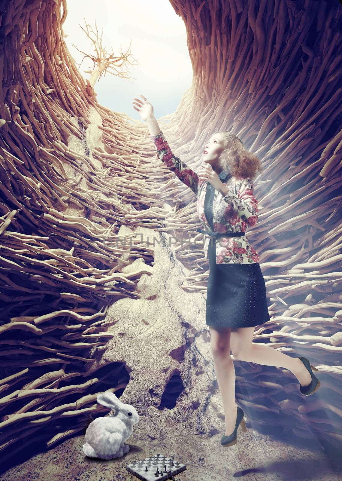 girl flies out of a deep hole toward the sunlight. creative concept