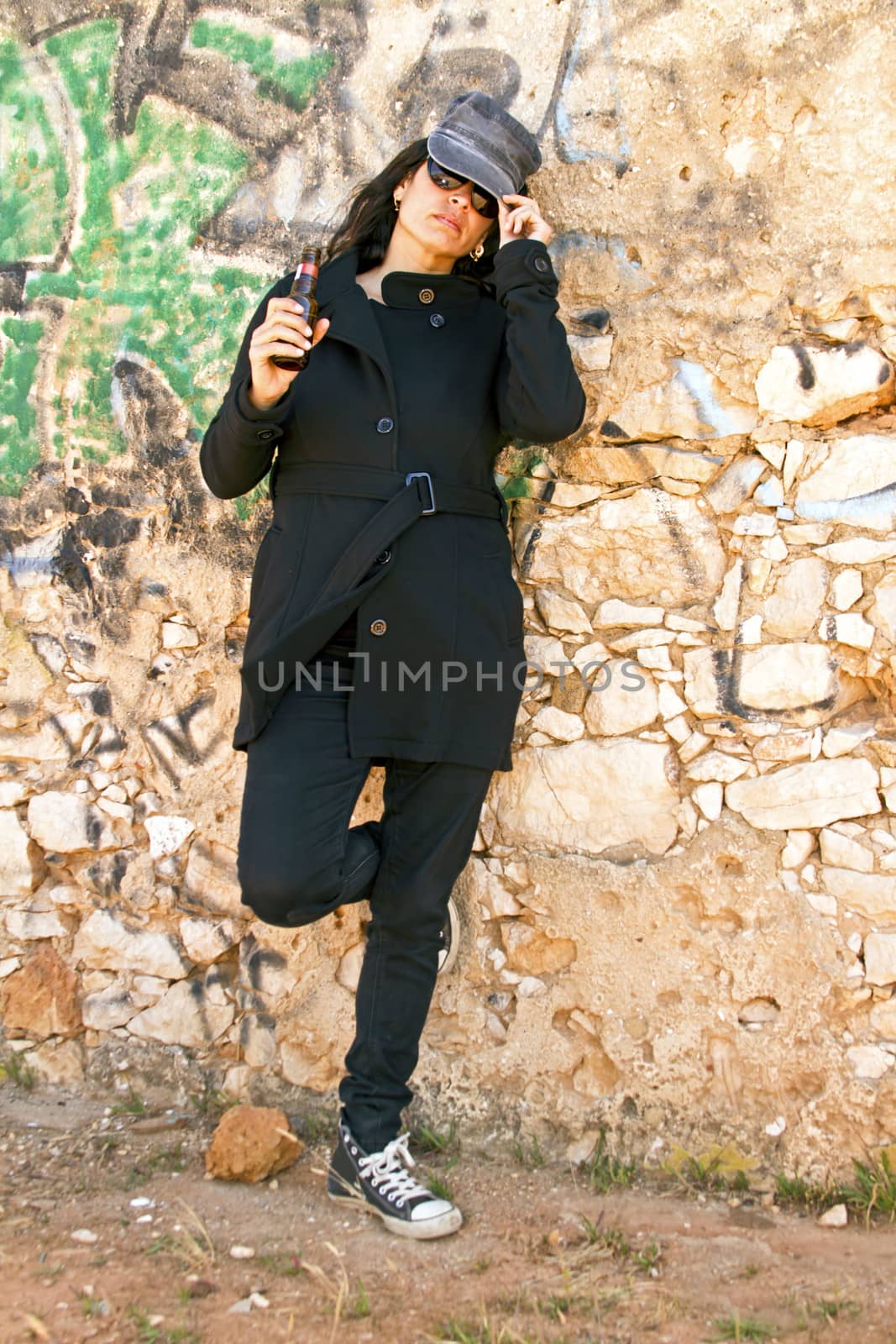 Woman in black at the graffiti brick wall by devy