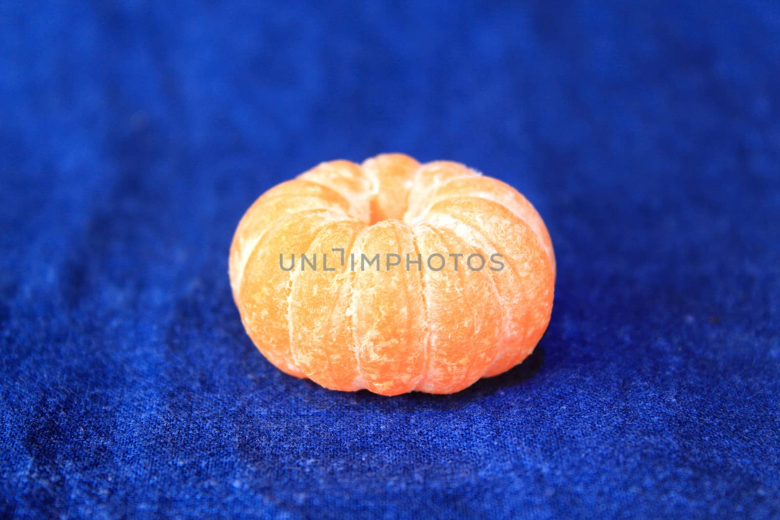 Orange mandarin on blue background