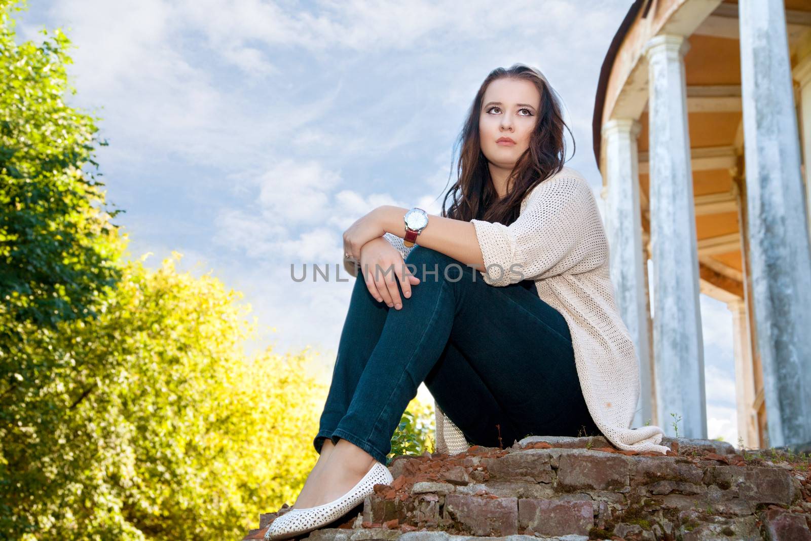  plus size girl sits on an old brick wall in the summer evening by alarich