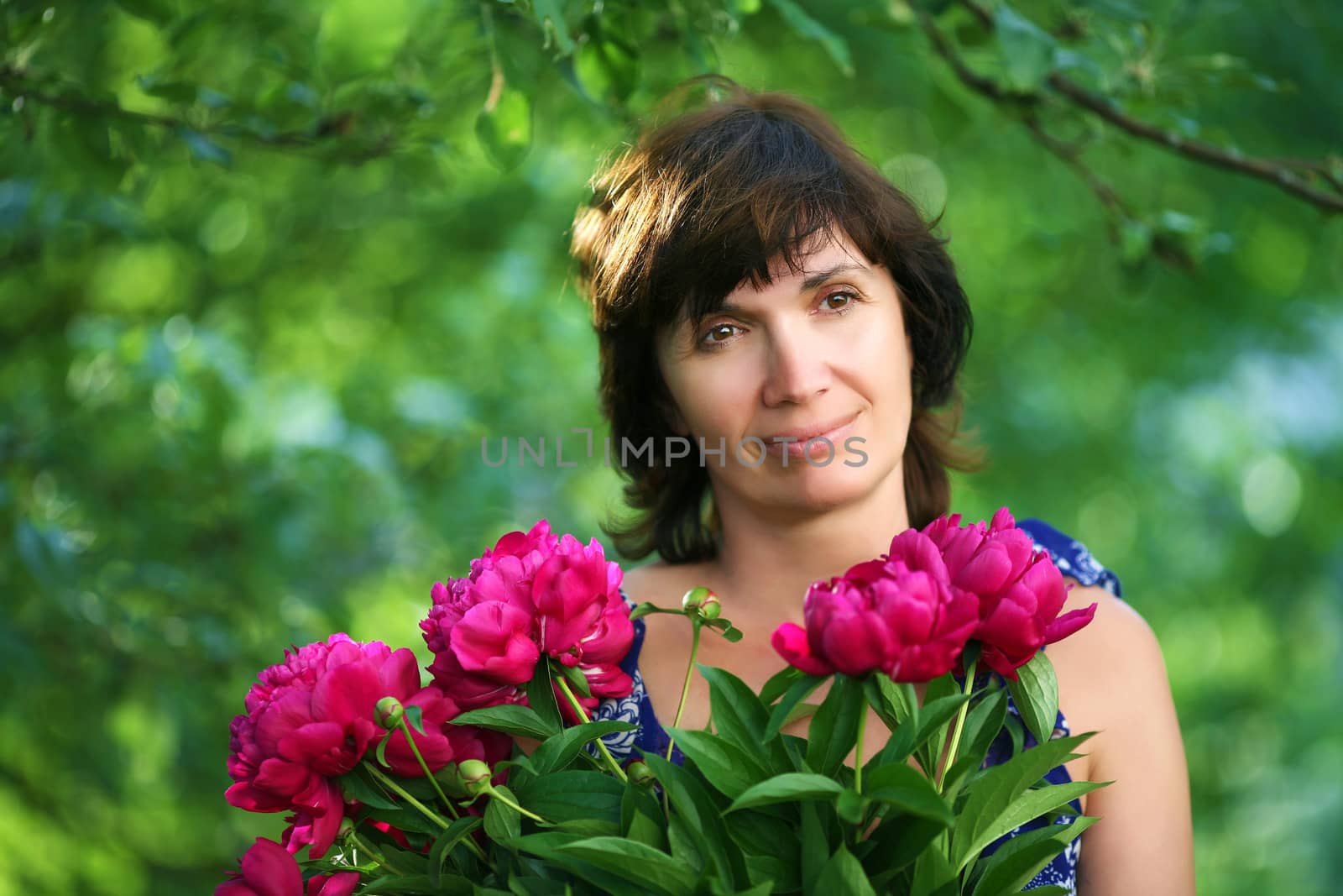 woman  in a garden with  bunch of flowers soft focus