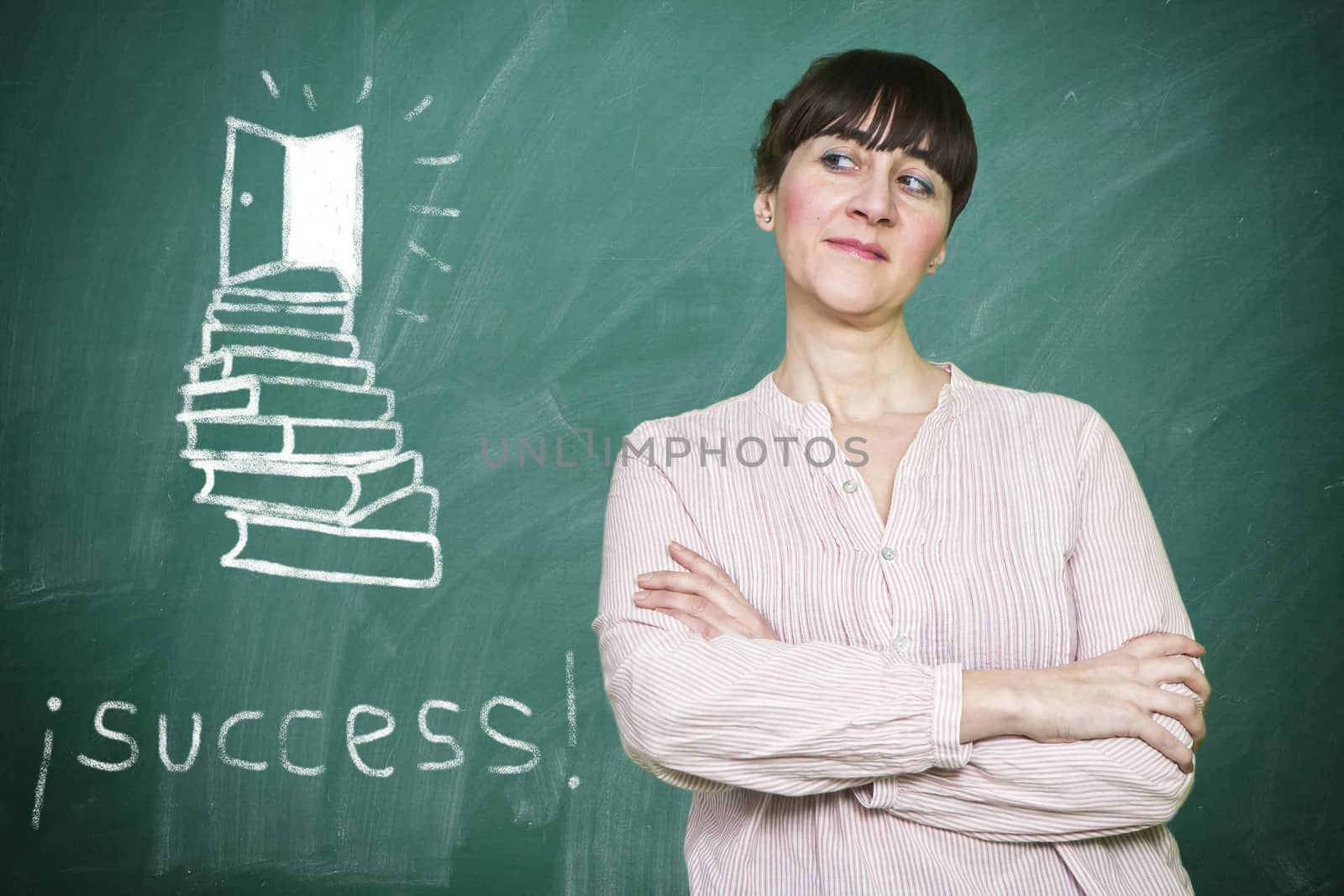 Woman smiles writes on a blackboard the concept of success