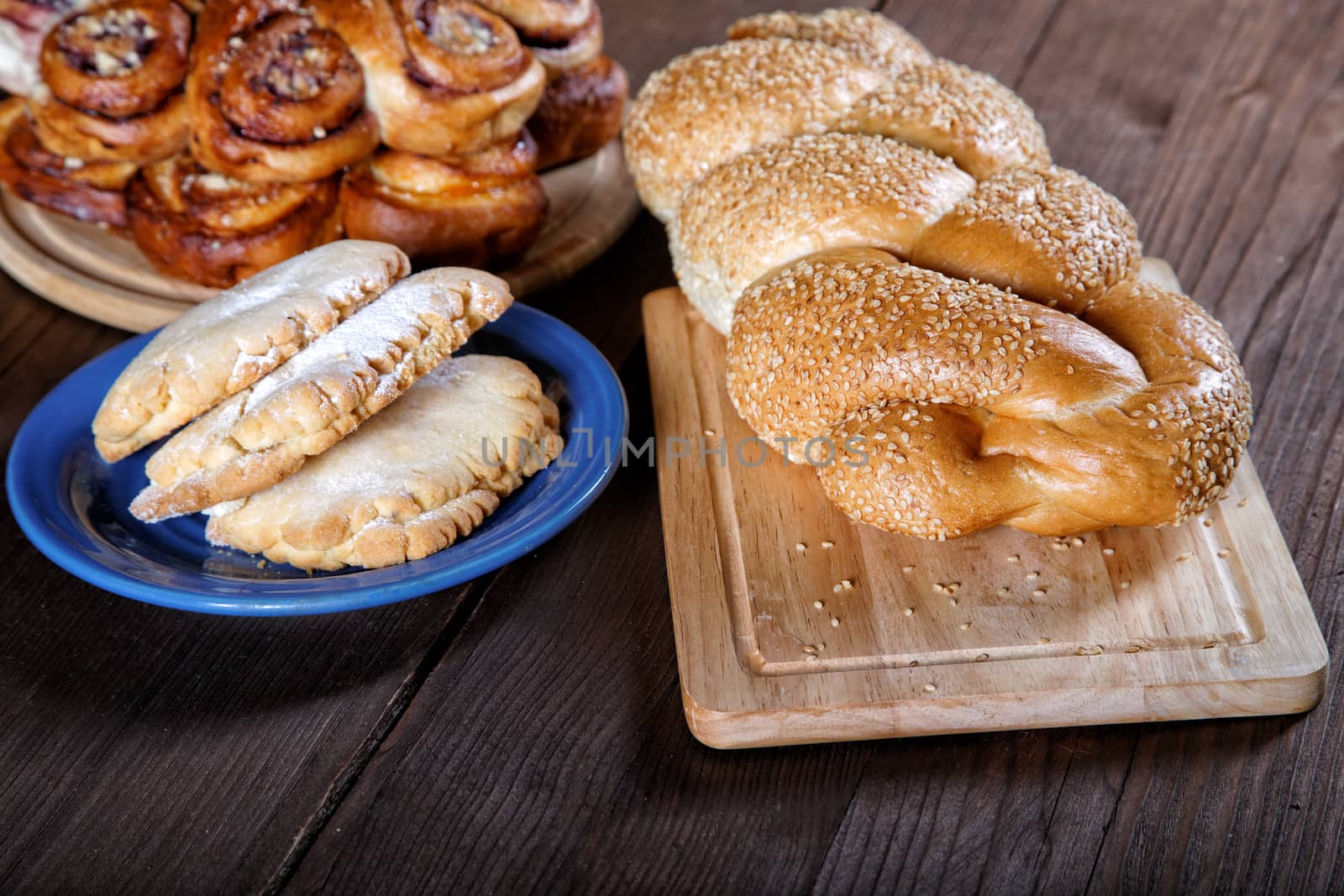 Still-life with rolls and pies on a kitchen table