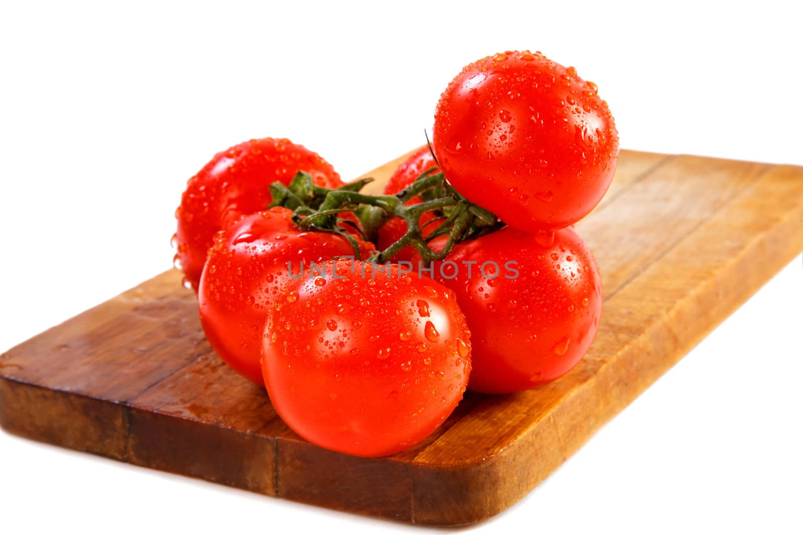 Branch of tomatoes with water drops on a white background