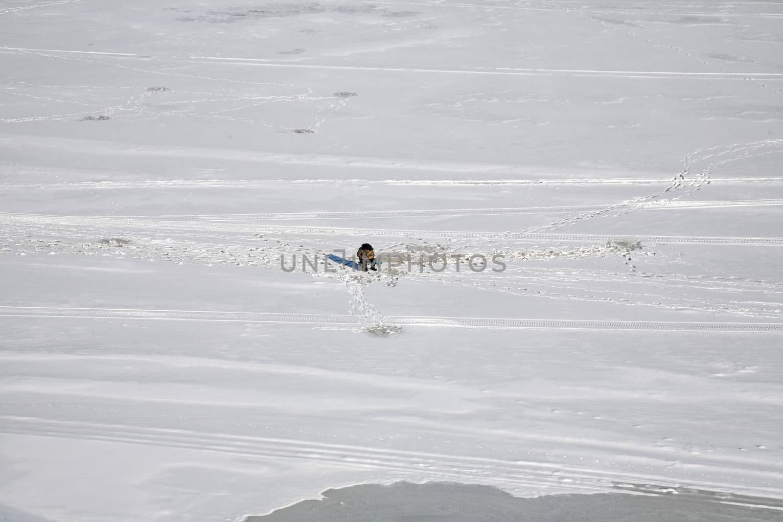 fisherman in  winter on the frozen river