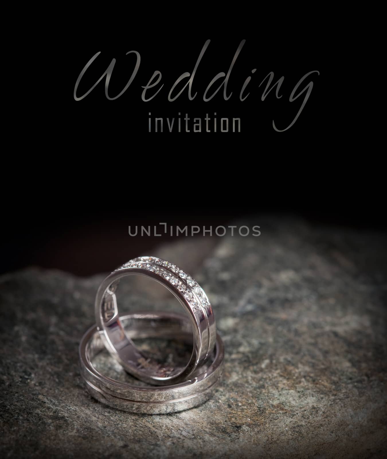 Two silver rings on rock - wedding invitation
