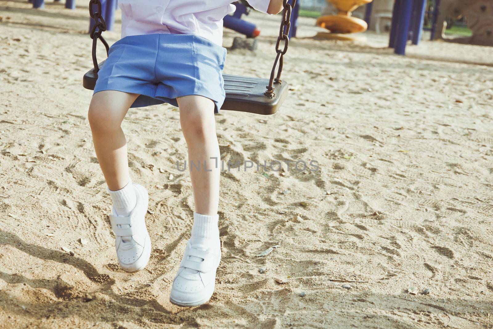 Little child on a swing in the park.